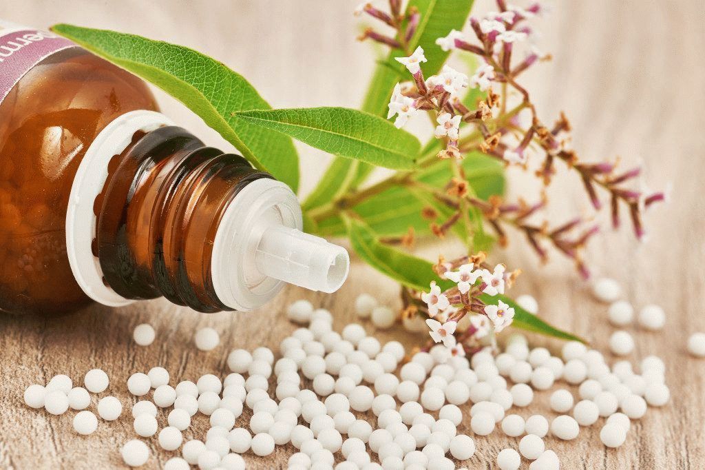 Homeopatiske granulater spredt på et trebord